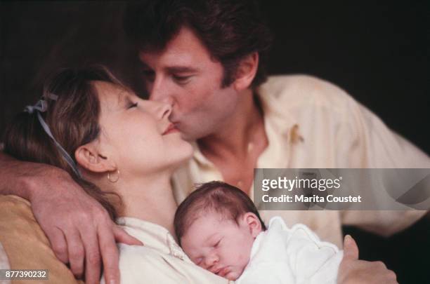 French actress Nathalie Baye and partner, singer and actor Johnny Hallyday with their newborn baby girl, Laura Smet, 25th November 1983