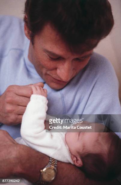French singer and actor Johnny Hallyday with his newborn daughter Laura Smet, 24th November 1983
