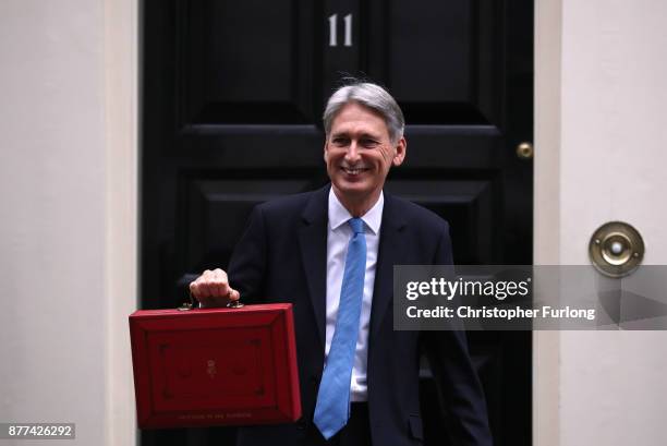 Britain's Chancellor of the Exchequer Philip Hammond holds the red case as he departs 11 Downing Street to deliver his budget to Parliament on...