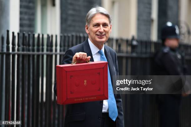 Britain's Chancellor of the Exchequer Philip Hammond holds the red case as he departs 11 Downing Street to deliver his budget to Parliament on...