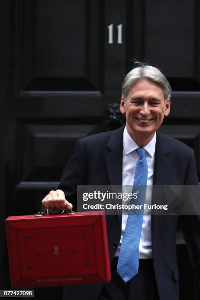 Britain's Chancellor of the Exchequer Philip Hammond holds the red case as he departs 11 Downing Street to deliver his budget to Parliament on...