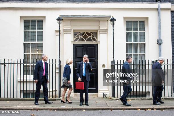 Britain's Chancellor of the Exchequer Philip Hammond holds the red case as he departs 11 Downing Street to deliver his budget to Parliament on...