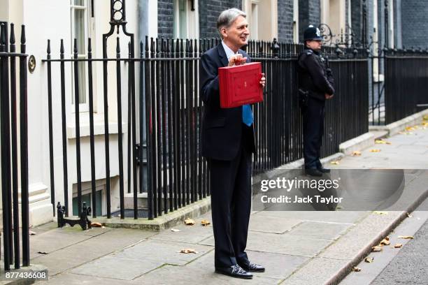 Britain's Chancellor of the Exchequer Philip Hammond holds the red case as he departs 11 Downing Street to deliver his budget to Parliament on...