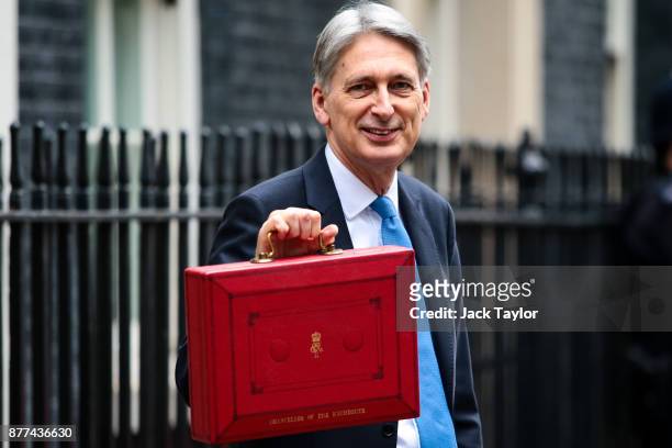 Britain's Chancellor of the Exchequer Philip Hammond holds the red case as he departs 11 Downing Street to deliver his budget to Parliament on...
