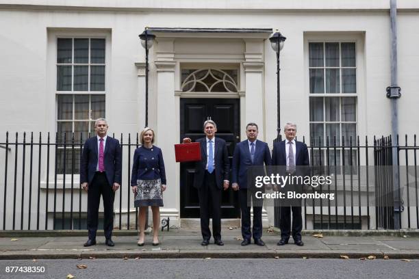 Philip Hammond, U.K. Chancellor of the exchequer, center, holds the dispatch box containing the budget, as he poses for photographs with, left to...