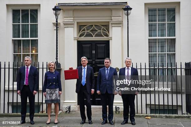 Britain's Chancellor of the Exchequer Philip Hammond holds the red case as he departs 11 Downing Street to deliver his budget to Parliament on...