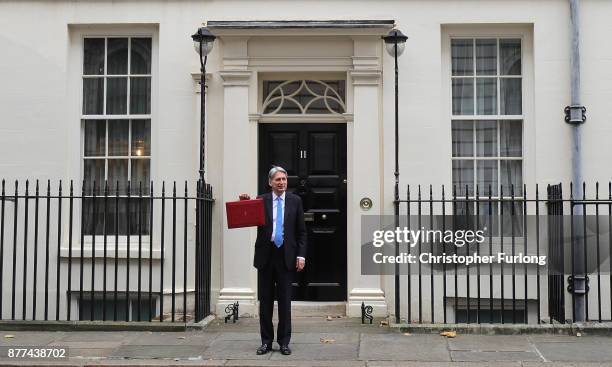 Britain's Chancellor of the Exchequer Philip Hammond holds the red case as he departs 11 Downing Street to deliver his budget to Parliament on...