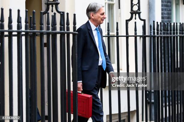 Britain's Chancellor of the Exchequer Philip Hammond holds the red case as he departs 11 Downing Street to deliver his budget to Parliament on...