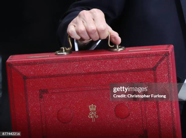 Britain's Chancellor of the Exchequer Philip Hammond holds the red case as he departs 11 Downing Street to deliver his budget to Parliament on...