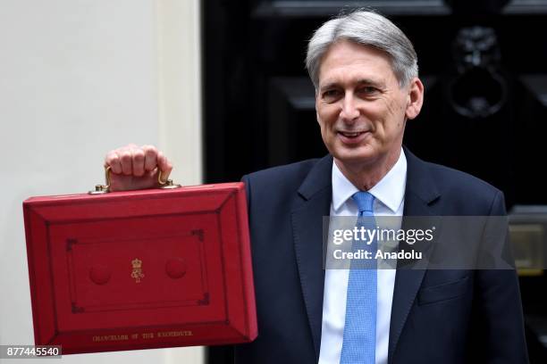 Britain's Chancellor of the Exchequer Philip Hammond holds the red case as he departs 11 Downing Street to deliver his budget to Parliament on...