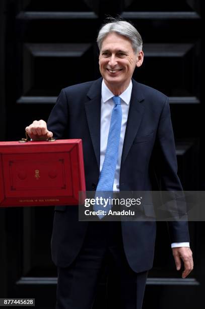 Britain's Chancellor of the Exchequer Philip Hammond holds the red case as he departs 11 Downing Street to deliver his budget to Parliament on...