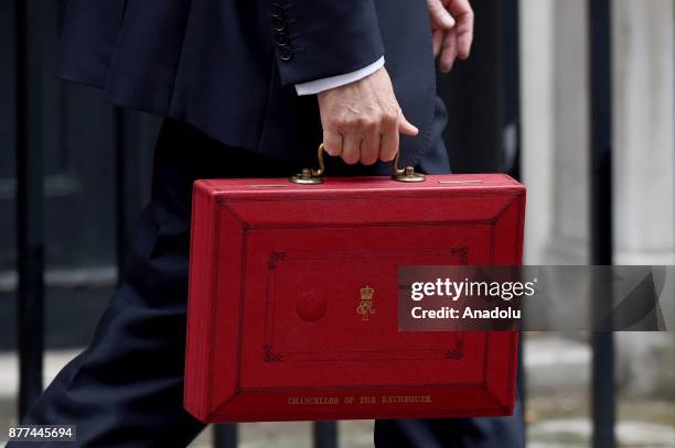 Britain's Chancellor of the Exchequer Philip Hammond holds the red case as he departs 11 Downing Street to deliver his budget to Parliament on...