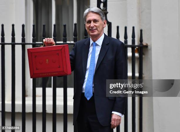 Britain's Chancellor of the Exchequer Philip Hammond holds the red case as he departs 11 Downing Street to deliver his budget to Parliament on...