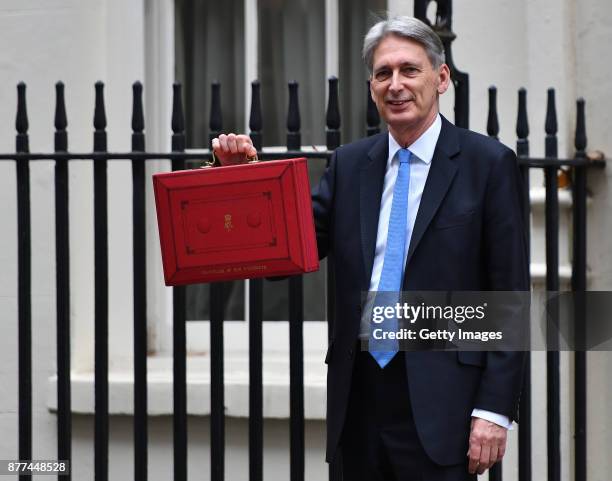 Britain's Chancellor of the Exchequer Philip Hammond holds the red case as he departs 11 Downing Street to deliver his budget to Parliament on...