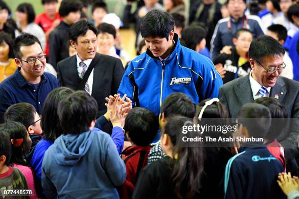 Shohei Otani of Hokkaido Nippon Ham Fighters high fives with children during a talk session on November 22, 2017 in Tsukigata, Hokkaido, Japan.