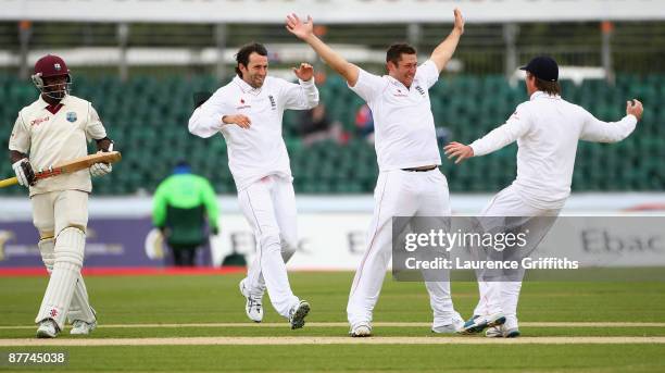Tim Bresnan of England is congratulated on the wicket of Fidel Edwards of the West Indies by Graeme Swan and Graham Onions during day five of the...