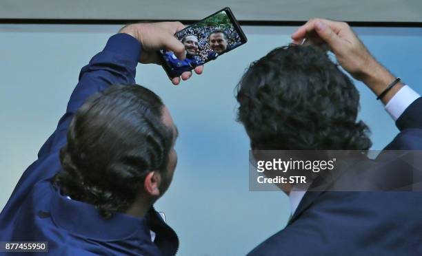 Lebanese prime minister Saad Hariri poses for a selfie with Lebanese singer Ragheb Alama upon his arrival at his home in Beirut on November 22, 2017....