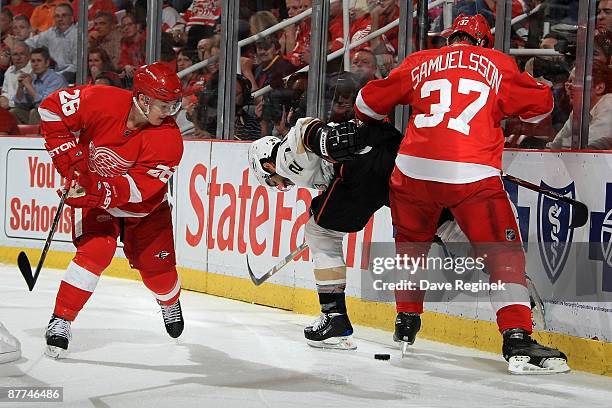 Scott Niedermayer of the Anaheim Ducks, Mikael Samuelsson and Jiri Hudler of the Detroit Red Wings fight for the puck during Game Seven of the...