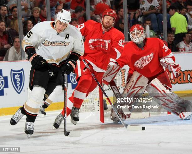 Ryan Getzlaf of the Anaheim Ducks and Johan Franzen of the Detroit Red Wings skate to the puck while Chris Osgood watches during Game Seven of the...