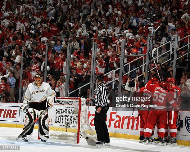 Jonas Hiller of the Anaheim Ducks looks down as a group of the Detroit Red Wings celebrate after a goal during Game Seven of the Western Conference...