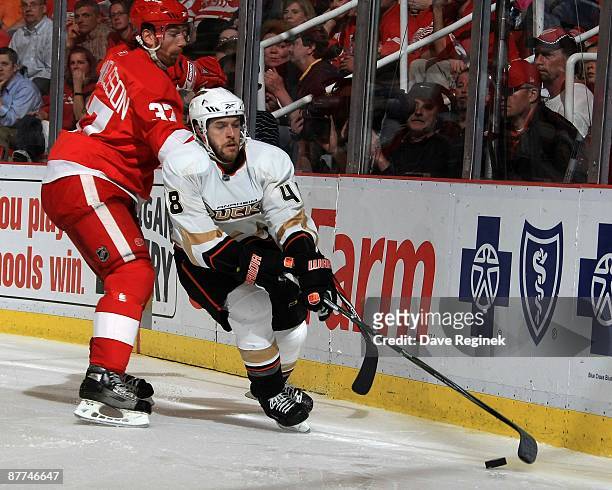 Andrew Ebbett of the Anaheim Ducks skates with the puck as Mikael Samuelsson of the Detroit Red Wings defends him during Game Seven of the Western...