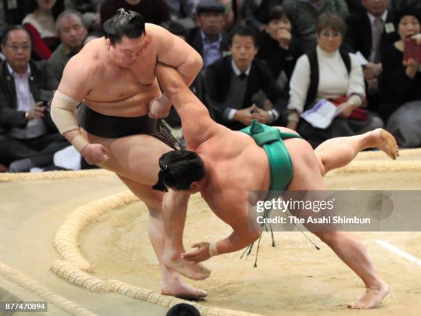 Sekiwake Yoshikaze pushes Mongolian yokozuna Hakuho out of the ring to win during day eleven of the Grand Sumo Kyushu Tournament at Fukuoka...