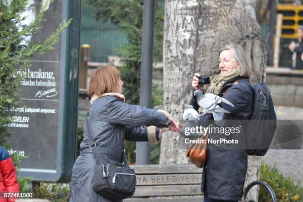 Women take pictures of pigeons at the Kugulu Park during a cold autumn day in Ankara, Turkey on November 22, 2017.
