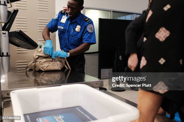 Transportation Security Administration worker screens passengers at LaGuardia Airport on the day before Thanksgiving, the nation's busiest travel day...