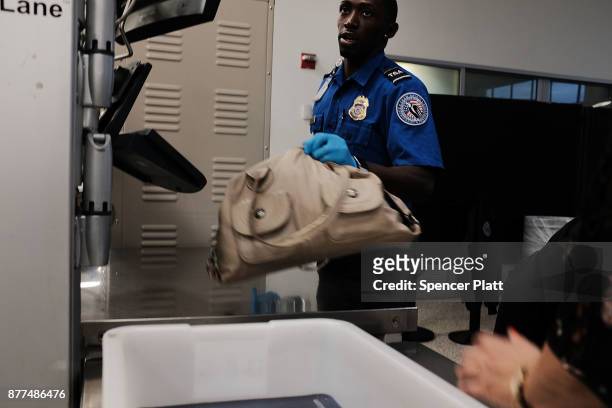 Transportation Security Administration worker screens passengers at LaGuardia Airport on the day before Thanksgiving, the nation's busiest travel day...