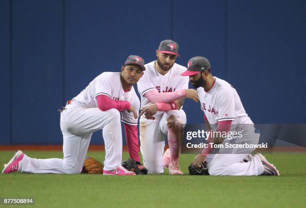 Ezequiel Carrera of the Toronto Blue Jays and Kevin Pillar and Jose Bautista gather in center field during a pitching change in the seventh inning...