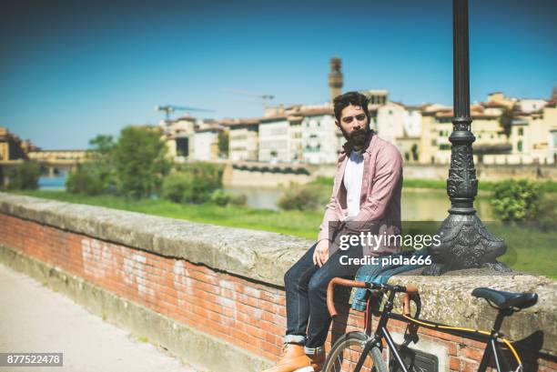 hipster kerl mit fahrrad in florenz, italien - fluss arno stock-fotos und bilder