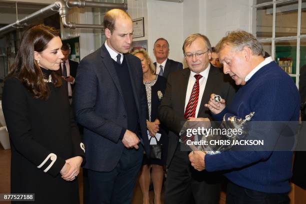 Britain's Prince William, Duke of Cambridge and Britain's Catherine, Duchess of Cambridge gesture during their visit to Acme Whistles, the creator of...