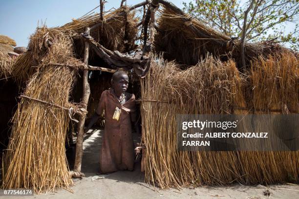 Akuach Ane, a displaced grandmother of three children, stands at the entrance to her shelter at an Internally Displaced Person camp formed by local...