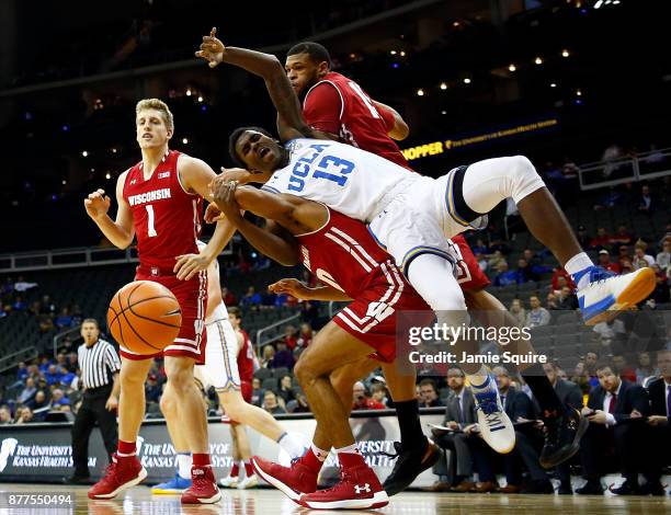 Kris Wilkes of the UCLA Bruins falls over D'Mitrik Trice of the Wisconsin Badgers while competing for a rebound during the National Collegiate...