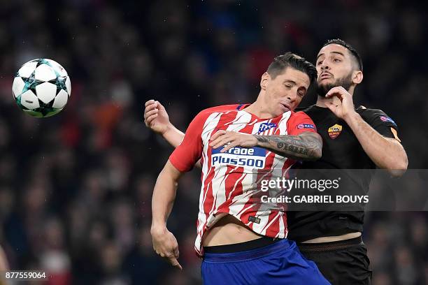 Atletico Madrid's Spanish forward Fernando Torres heads the ball with Roma's Greek defender Kostas Manolas during the UEFA Champions League group C...