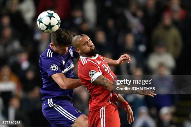 Bayern Munich's Chilean midfielder Arturo Vidal heads the ball with Anderlecht's Belgian midfielder Leander Dendoncker during the UEFA Champions...