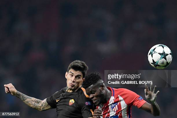 Atletico Madrid's Ghanaian midfielder Thomas heads the ball with Roma's Argentinian midfielder Diego Perotti during the UEFA Champions League group C...