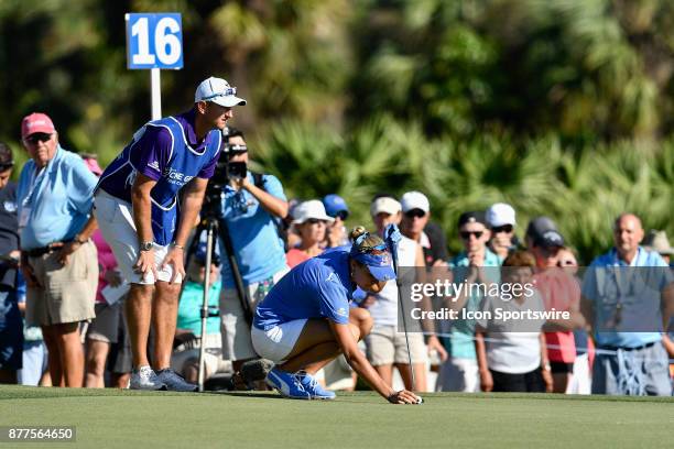 Lexi Thompson of the United States lines up her putt on the sixteenth hole while her caddie, Kevin McAlpine, looks from behind during the final round...