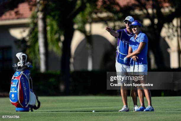 Lexi Thompson of the United States and her caddie, Kevin McAlpine, discuss her shot approach shot on the seventeenth hole during the final round of...