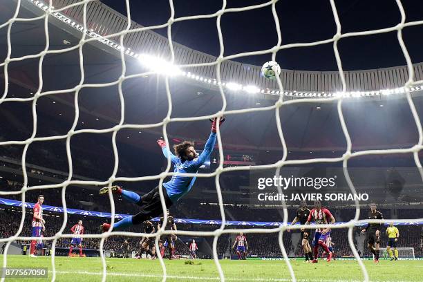 Roma's Brazilian goalkeeper Alisson punches the ball away during the UEFA Champions League group C football match between Atletico Madrid and AS Roma...