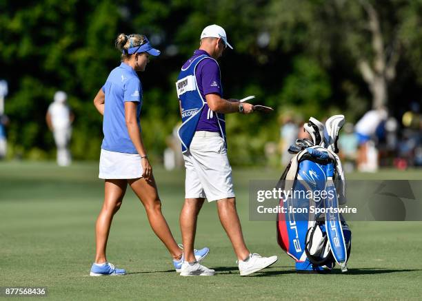 Lexi Thompson of the United States and her caddie, Kevin McAlpine discuss her shot on the fourteenth hole during the final round of the LPGA CME...