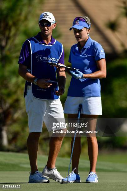 Lexi Thompson of the United States and her caddie, Kevin McAlpine discuss her shot on the fourteenth hole during the final round of the LPGA CME...