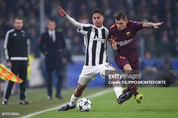 Juventus' forward from Argentina Paulo Dybala fights for the ball with Barcelona's French defender Lucas Digne during the UEFA Champions League Group...