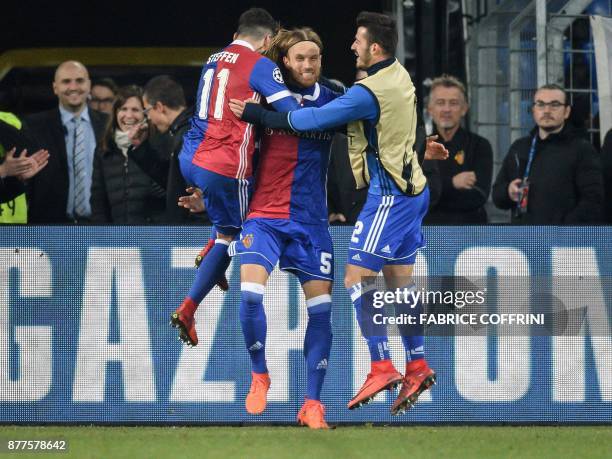 Basel's Swiss defender Michael Lang celebrates with teammates after scoring a goal during the UEFA Champions League Group A football match between FC...