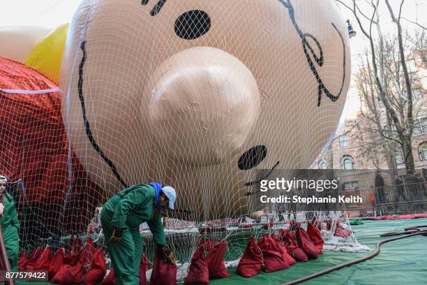 Worker on the Macy's inflation team secures the Charlie Brown balloon near Central Park ahead of the Macy's Thanksgiving Day parade on November 22,...