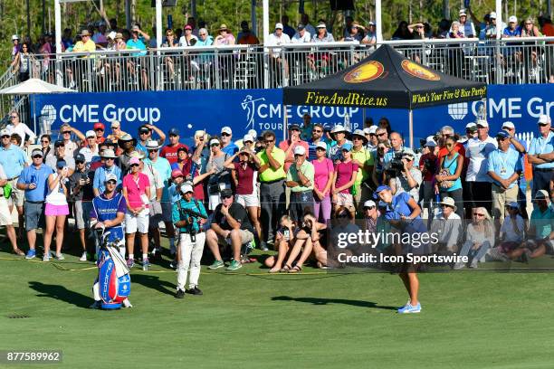 Lexi Thompson of the United States chips onto the green in front of a large crowd on the seventeenth hole during the final round of the LPGA CME...