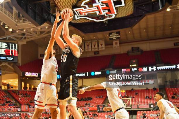 Matthew Pegram of the Wofford Terriers shoots the ball over Zach Smith of the Texas Tech Red Raiders during the first half of the game between the...