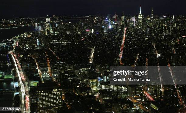 Car headlights and taillights shine on crowded northbound and southbound streets in Manhattan after sunset ahead of the Thanksgiving holiday on...