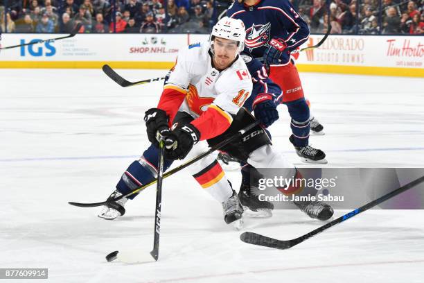 Mikael Backlund of the Calgary Flames attempts to keep the puck from Jordan Schroeder of the Columbus Blue Jackets during the second period of a game...