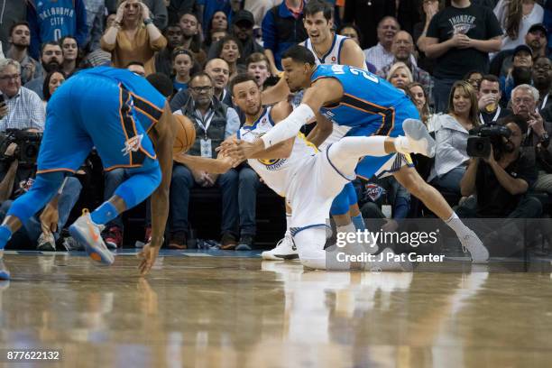 Stephen Curry of the Golden State Warriors looks to pass the ball as Andre Roberson of the Oklahoma City Thunder applies pressure during the first...